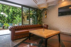 a brown leather couch in a room with a table at Lara Park Hotel in Antalya