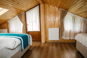 a bedroom with two beds and two windows at Ayder Palas Apart Hotel in Ayder Yaylasi