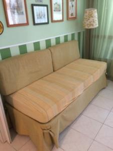 um sofá castanho num quarto com um candeeiro em Marina Di Bibbona em Marina di Bibbona