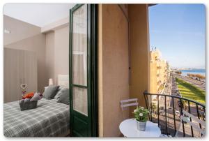 a bedroom with a bed and a balcony with a view at B&B Monica's House in Salerno