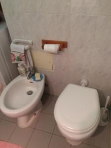 uma casa de banho com um WC branco e um lavatório. em Marina Di Bibbona em Marina di Bibbona