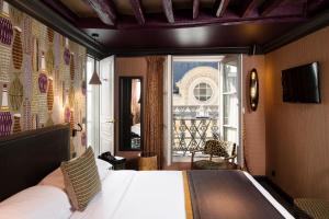 um quarto de hotel com uma cama e uma janela em Hôtel Les Dames du Panthéon em Paris
