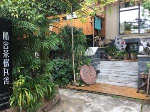 a house with a bunch of plants in front of it at Zen Tea House Seven Stars Park in Guilin