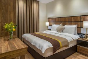 a bedroom with a large bed with a wooden headboard at Classical Hotel Suites in Jeddah +19 photos