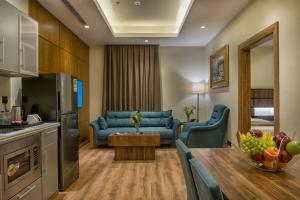 a kitchen and a living room with a couch and a table at Classical Hotel Suites in Jeddah