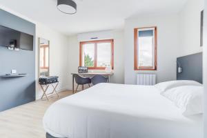 a bedroom with a large white bed and a desk at Cerise Nantes La Beaujoire in Nantes