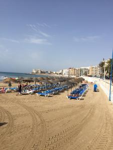 una playa con muchas tumbonas y el océano en Tus vacaciones junto al mar, en Torrevieja 50 fotos más