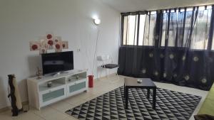 Il comprend un salon doté d'une télévision à écran plat et d'une table. dans l'établissement Apartamento Mare Verde, à Adeje