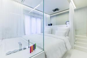 a bathroom with a mirror, toilet and bathtub at The Grove Design Hotel in Tbilisi City