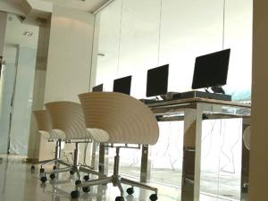 un bureau avec un bureau avec plusieurs chaises et un ordinateur dans l'établissement Tango Vibrant Living Hotel - SHA Extra Plus, à Bangkok