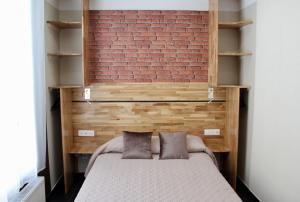 a bedroom with a bed and a brick wall at Hotel des Pyrénées in Paris