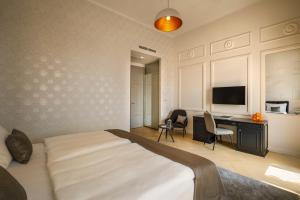 a bedroom with a bed and a desk and a television at Hotel Imperial - Liburnia in Opatija