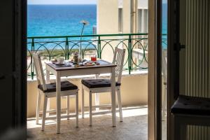 uma mesa e cadeiras numa varanda com o oceano em B&B Bellavista Gallipoli em Gallipoli