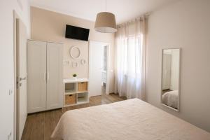 a white bedroom with a bed and a mirror at B&B Bellavista Gallipoli in Gallipoli