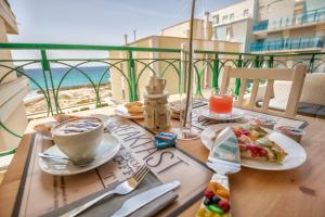 a table with food and coffee and a view of the ocean at B&B Bellavista Gallipoli in Gallipoli