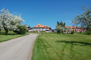 une route en face d'un bâtiment planté d'arbres à fleurs dans l'établissement Dalecarlia Hotel & Spa, BW Premier Collection, à Tällberg