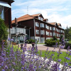 ein Gebäude mit lila Blumen davor in der Unterkunft Dalecarlia Hotel & Spa, BW Premier Collection in Tällberg