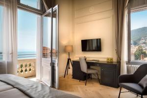 a bedroom with a bed and a desk with a television at Hotel Imperial - Liburnia in Opatija