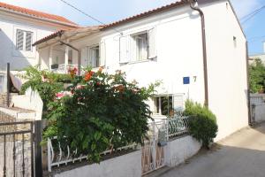 a white house with flowers on a fence at Mimi in Jadranovo