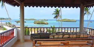 a balcony with a view of the ocean and a beach at Villa Volandrella - in front of Watamu Beach in Watamu