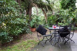 a table and chairs in a garden with plants at Melbourne Villa in Melbourne