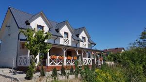 a large white house with a porch at Domki letniskowe Chabrowa 1 in Sianozety