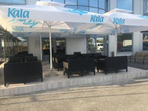 restauracja ze stołami i krzesłami pod parasolami w obiekcie Royal Apartments & Rooms w Zagrzebiu