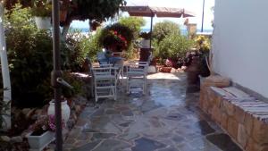 a patio with chairs and an umbrella at Studios Antoniou in Skala