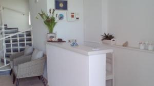 a white room with a counter and a chair at Studios Antoniou in Skala