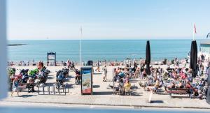 a crowd of people sitting on a beach at Sea view Ar Lan y Mor LUXURY APARTMENT in Aberystwyth