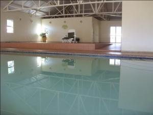 a swimming pool with its reflection in the water at Ezulwini Berg Resort in Ethels Drive