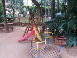 a playground with a slide in a park at Flat Conforto em Itaipava in Itaipava