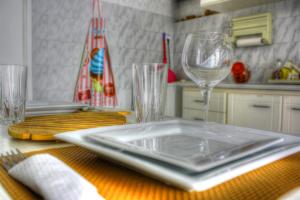 a table with a plate and two wine glasses on it at The Hot Pink Bike House in Parikia