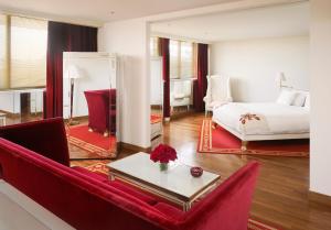 a living room with a red couch and a bed at Faena Hotel Buenos Aires in Buenos Aires