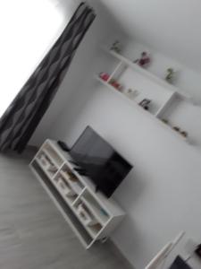 salon z telewizorem i białą półką w obiekcie Le parisien w Costa Teguise