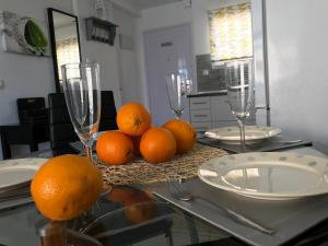 einen Tisch mit Gläsern und Orangen darüber in der Unterkunft Isla Verde Apartment in Torrevieja