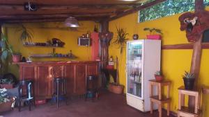 a yellow room with a refrigerator and some stools at Sweet Guest House in Puerto Iguazú