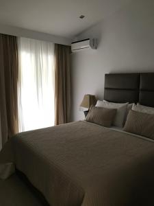 a bedroom with a large bed and a window at Golden View Residence in Dhërmi
