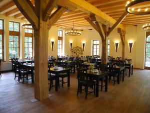 a restaurant with tables and chairs in a room with wooden ceilings at Gästehof Cafe im Schafstall in Barsinghausen