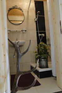baño con lavabo, espejo y planta en Rinntaverne en Palfau