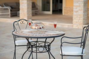 Castelnuovo CilentoにあるVilla Marchesaのテーブル(椅子2脚付)とワイン2杯