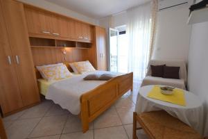 a bedroom with a bed and a couch and a table at Apartments Josipa in Malinska