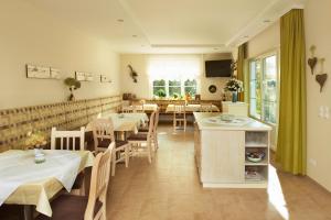 ein Restaurant mit Tischen und Stühlen in einem Zimmer in der Unterkunft Weingut Sommerhof in Mörbisch am See