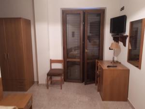 a living room with a wooden cabinet and a television at Hotel Edelweiss in Laino Borgo