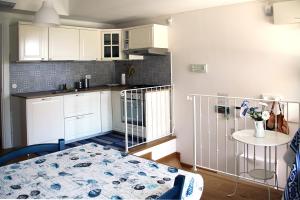 una cocina con armarios blancos y una mesa en una habitación en Appartamento mare Sirolo con garage privato, en Sirolo