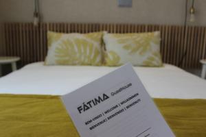 a sign sitting on top of a bed at Fátima GuestHouse in Fátima