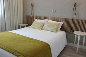 a bedroom with a large bed with two tables at Fátima GuestHouse in Fátima