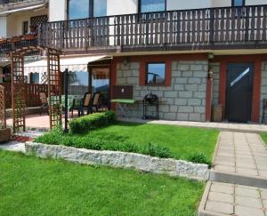 a house with a balcony and a yard with green grass at Apartament Rodzinny in Szklarska Poręba