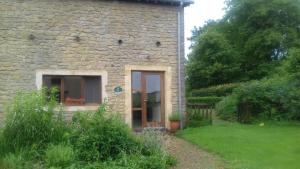 a stone house with a door in a yard at Gîte de Thirifays in Chiny +2 photos