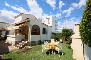 uma mesa e cadeiras no quintal de uma casa em Puerto Azul Casa Doro em Denia